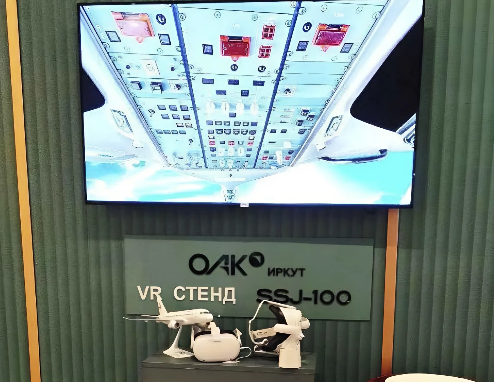 VR-стойка: на экране — верхний пульт кабины, ниже табличка, шлемы и модель SSJ-100