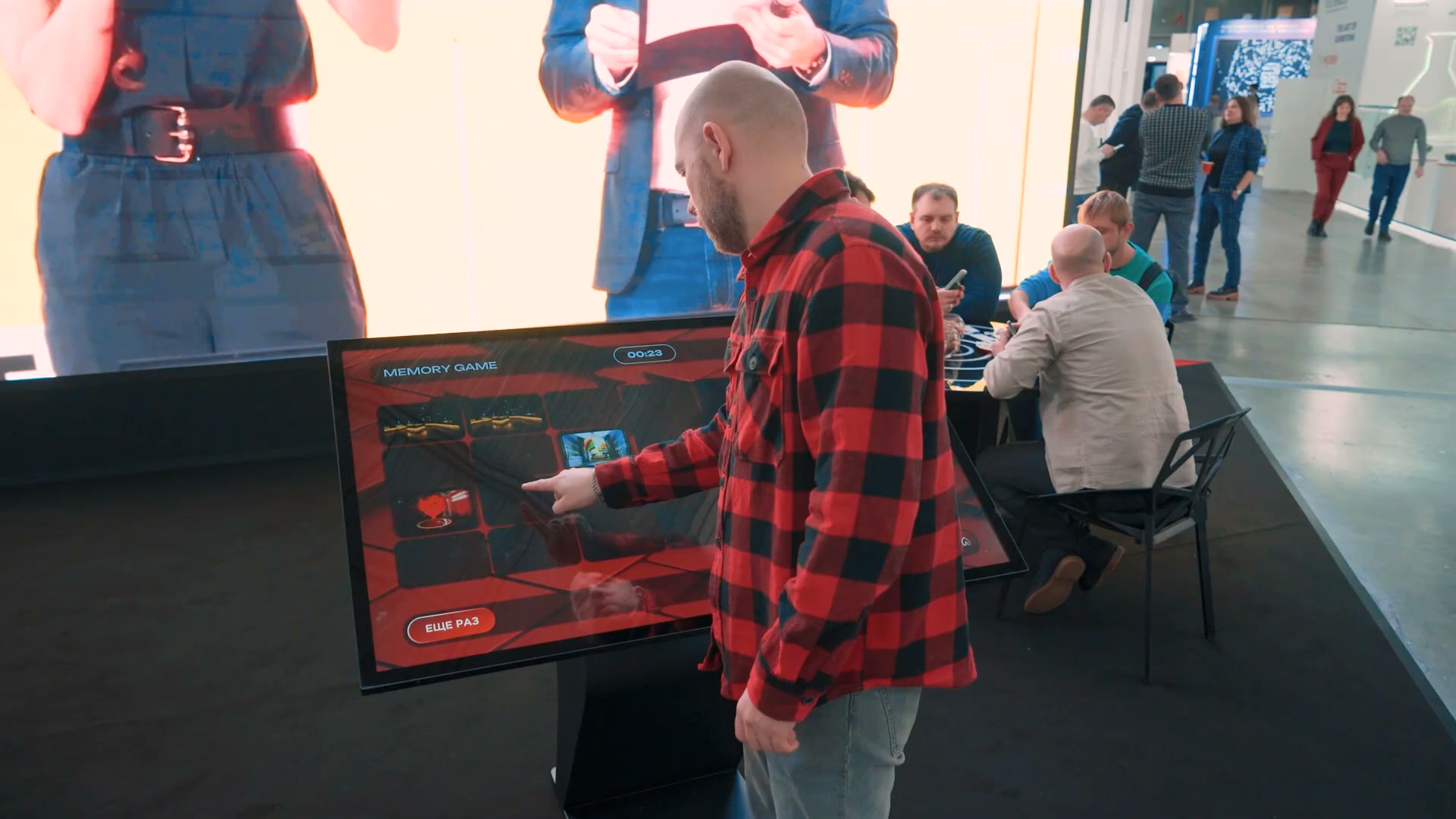 Посетитель открывает карточки игры «Память» на сенсорном столе, вверху экрана — таймер