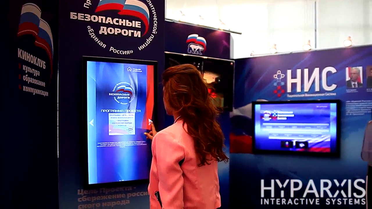 Девушка у вертикального сенсорного экрана проекта «Безопасные дороги»