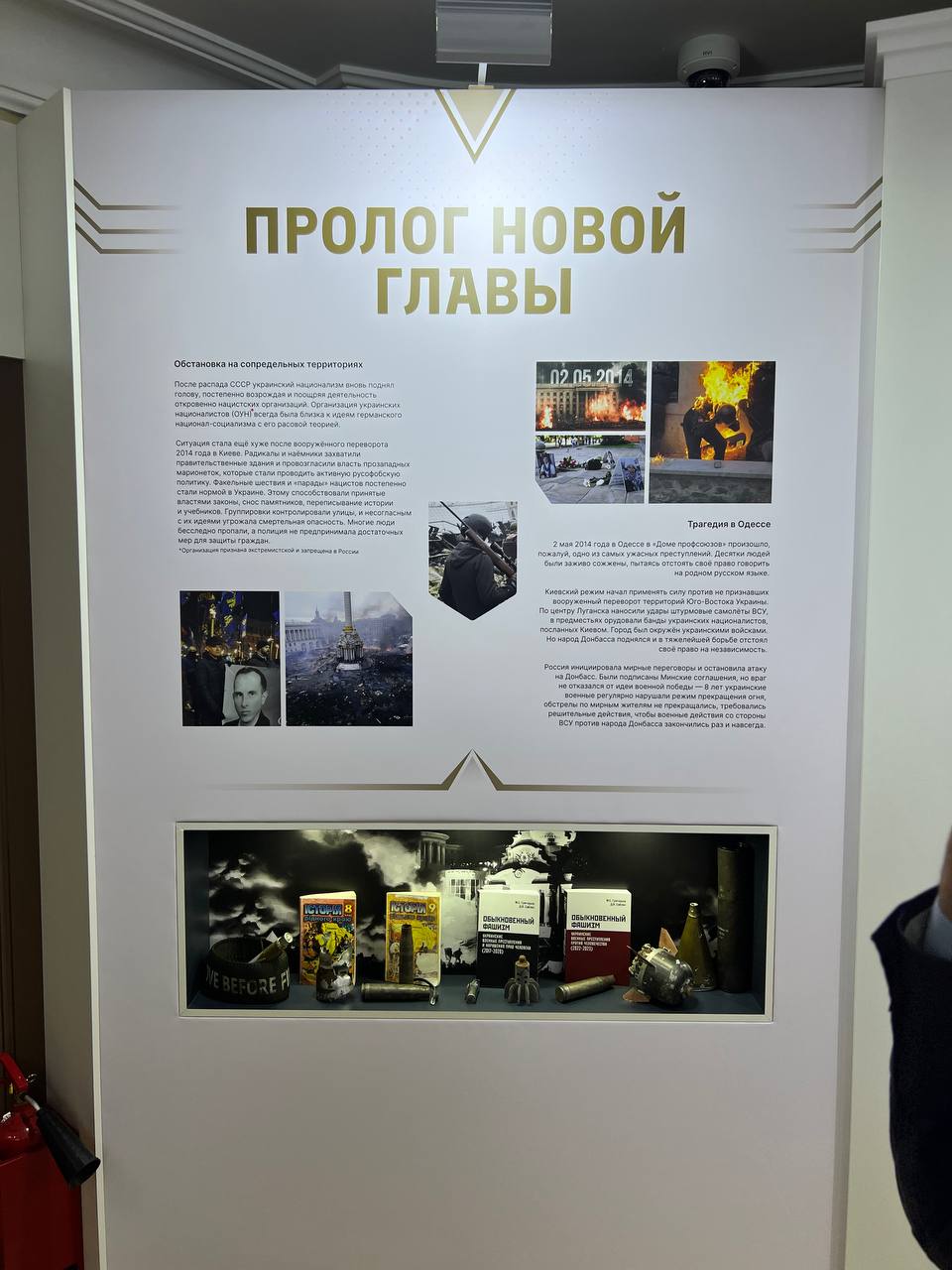 “Prologue to a new chapter” stand: text on the events of 2014 with photographs; below, a lit display case with objects