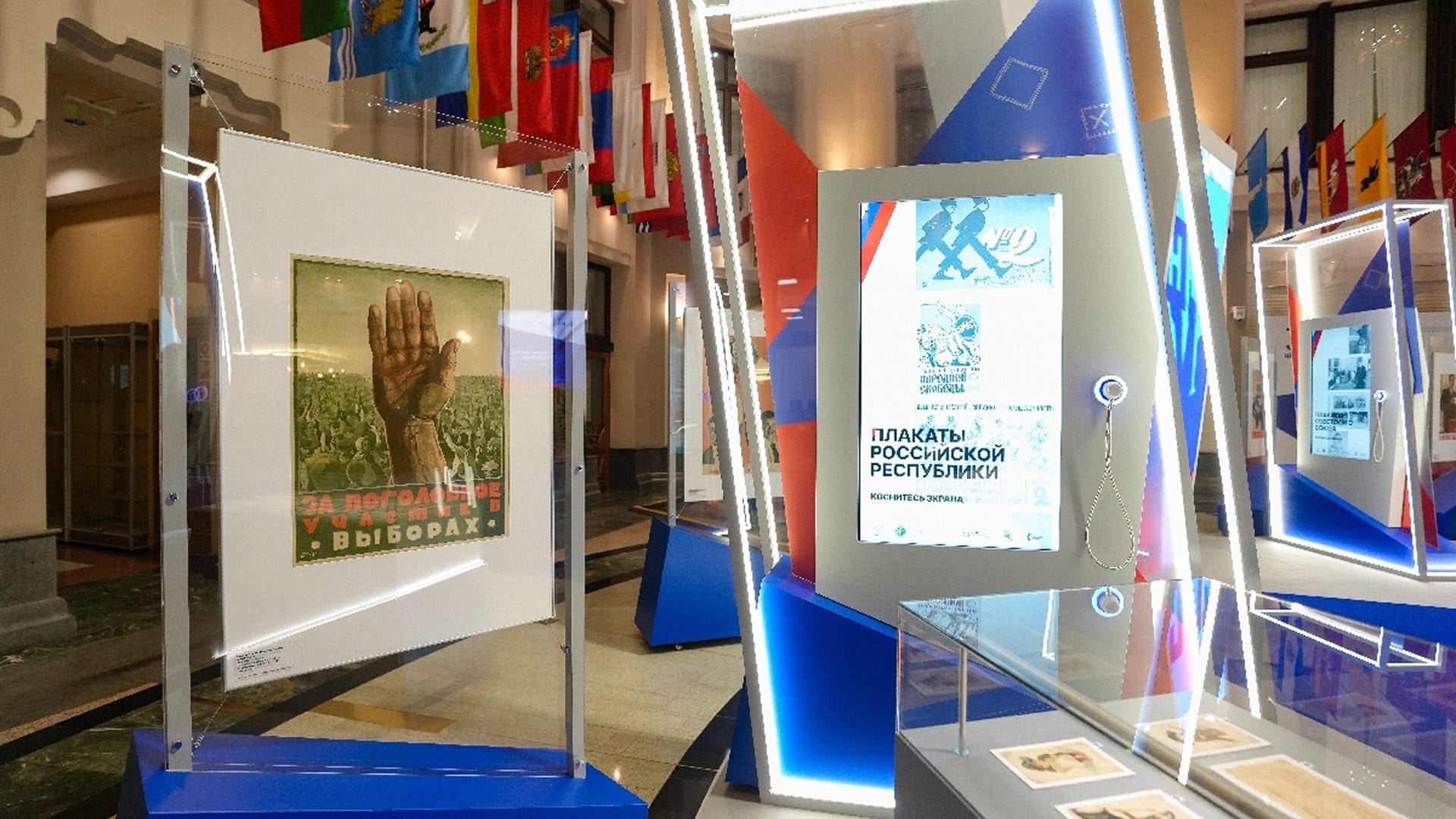 The poster “For universal participation in the elections” next to the vertical screen “Posters of the Russian Republic”
