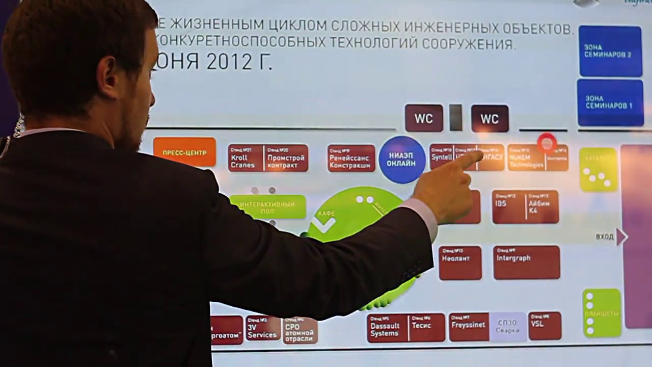 Мужчина выбирает стенд на схеме выставки форума 14–15 июня 2012 года