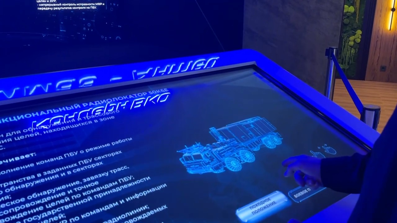 Touch table: the multifunction radar card, a visitor’s hand by the travelling and combat position buttons