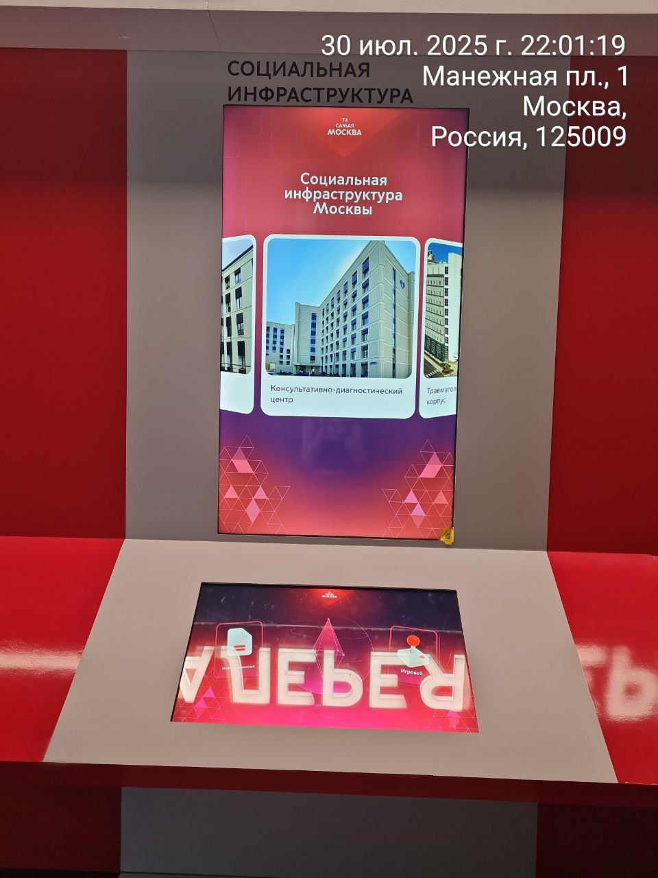 Стенд «Социальная инфраструктура»: на вертикальном экране — карусель объектов и карточка «Консультативно-диагностический центр»