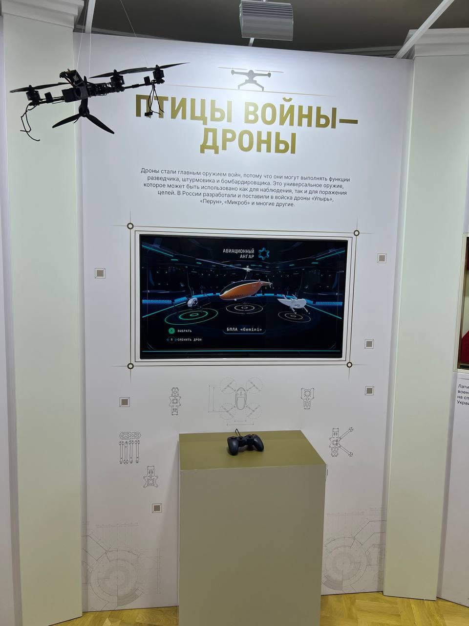 “Birds of war — drones”: the “Aviation hangar” game on the screen, a gamepad on a plinth