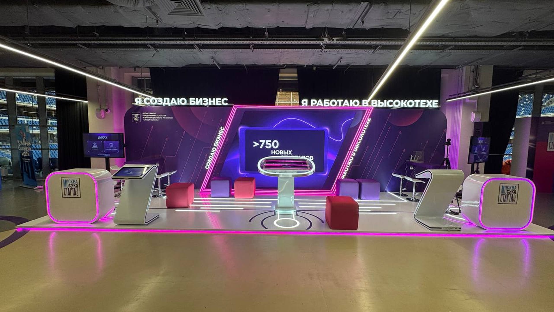 The stand from the front: two kiosks at the sides and a touch table in the centre